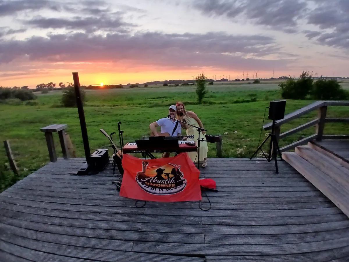 Die Bühne mit Banner vor dem Sonnenuntergang über den Feldern