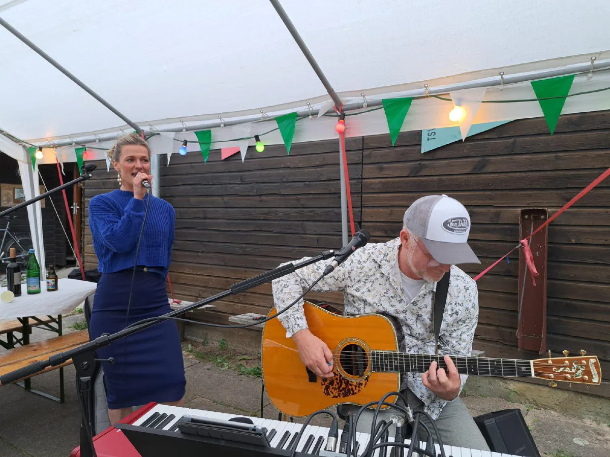 Dana singt, Stefan spielt Gitarre unter dem Partyzelt