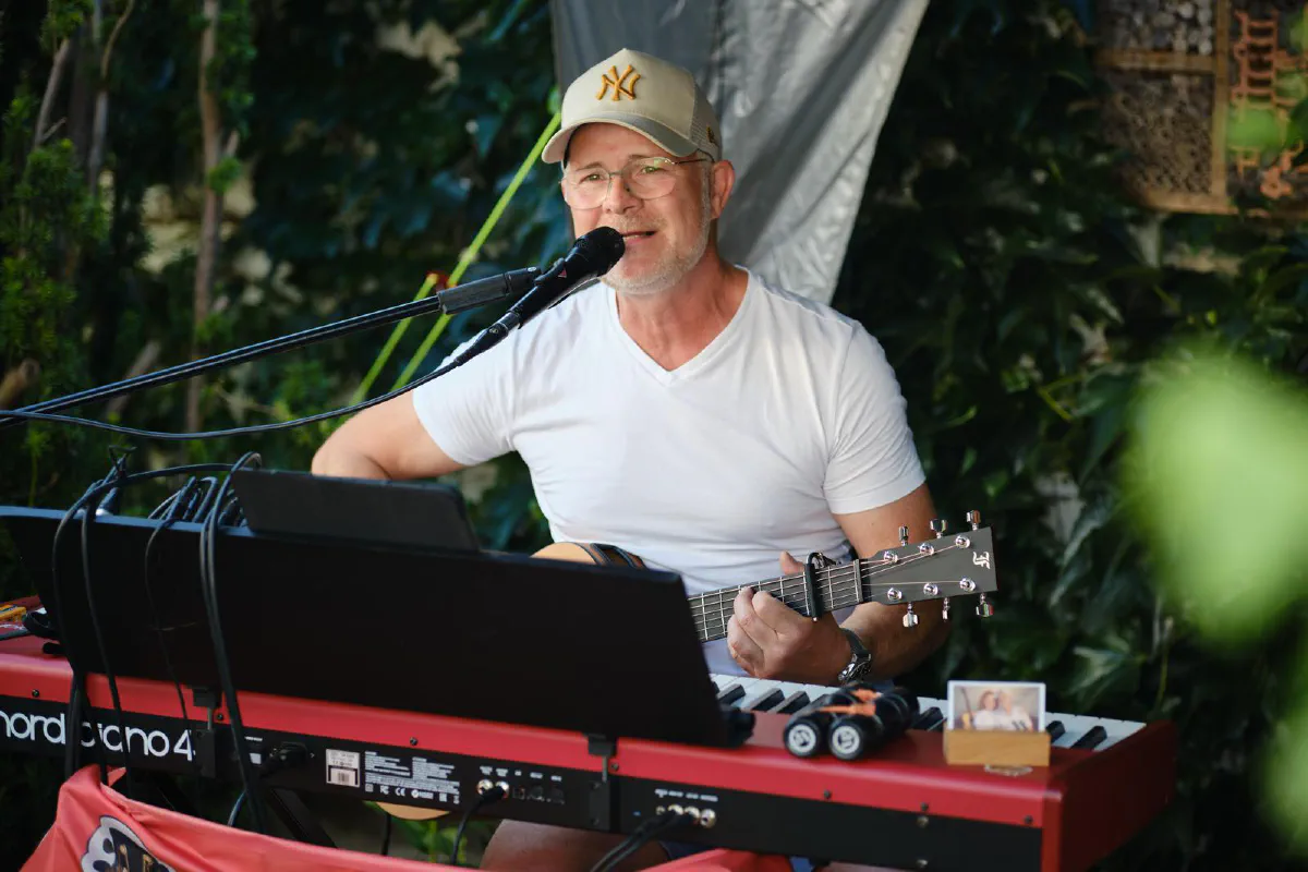 Stefan singt und spielt am roten Klavier im Grünen