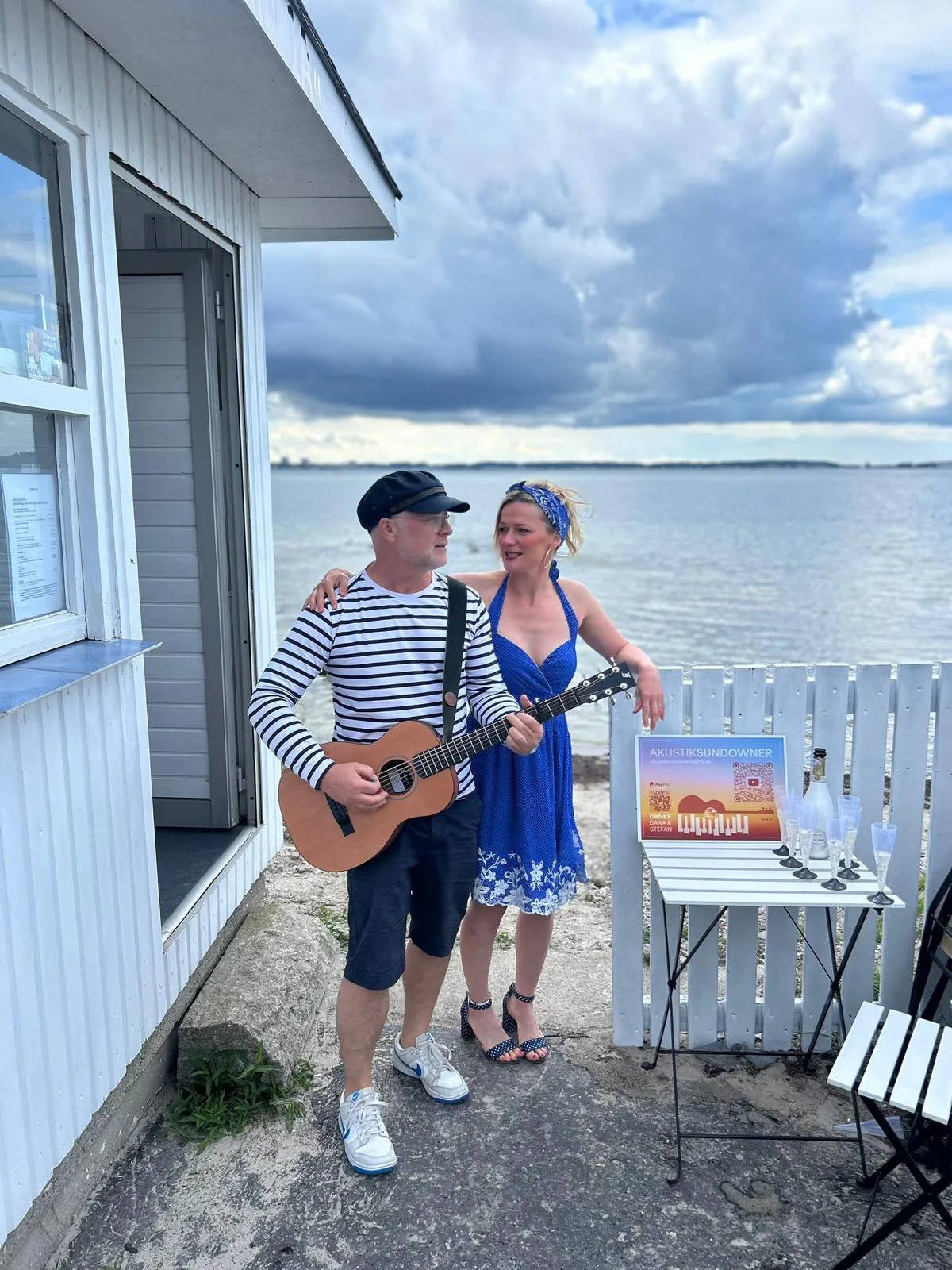 Dana und Stefan mit Gitarre vor einem Strandhaus an der Ostsee